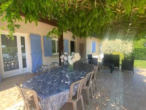 a table with chairs and a vase of flowers on it at L'Esprit Cottage in La Tranclière