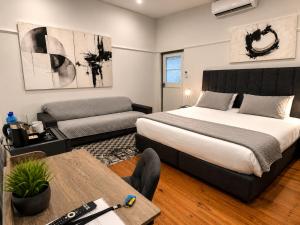 a bedroom with a bed and a couch and a table at 30 on 6th by 306 Accommodation in Bellville
