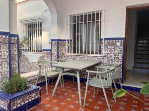 a table and chairs on a patio with tiles at Villa Alhelí del Aljarafe in Mairena del Aljarafe