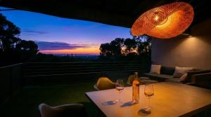 a table with two wine glasses on it with a sunset at Arty Provence, vue, calme et piscine chauffée dans les Alpilles proche St-Rémy-de-Provence in Saint-Étienne-du-Grès