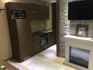 een keuken met een open haard en een flatscreen-tv bij Apartment Elvir in Kopaonik