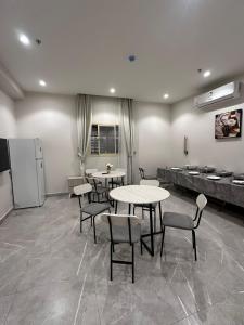 a room with tables and chairs and a refrigerator at فندق كتيفا نورث in Arar