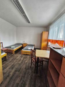a room with two beds and a table and chairs at Sokolovna in Bohumín