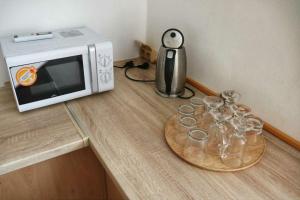a counter with a microwave and a tray of wine glasses at Sokolovna in Bohumín