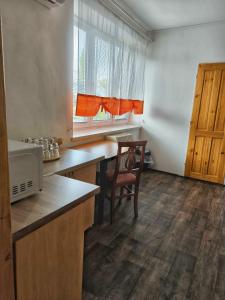 a kitchen with a table and a chair and a window at Sokolovna in Bohumín