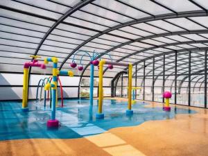 a large room with a water park with a playground at Mobil home Salsa in Litteau