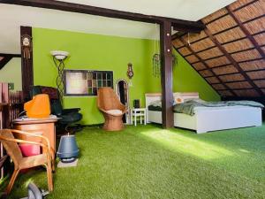 a bedroom with green walls and a bed and chairs at Tijd-Loos in Geeste