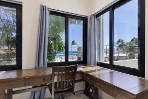 a dining room with a wooden table and windows at Ocean View Studio Near Los Barriles in Buenavista