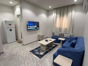 a living room with blue couches and a tv at فندق كتيفا نورث in Arar