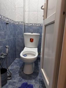 a bathroom with a toilet in a blue tiled room at Apartment in Lankaran in Lankaran
