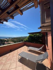 a patio with a table and chairs on a balcony at Appartamenti Cala d'Ambra in San Teodoro