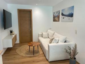 a living room with a white couch and a table at Apart Alma in Pfunds