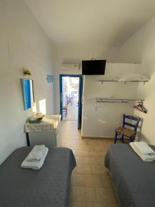 a room with two beds and a table and chairs at Hotel Glaros Lipsi in Leipsoi +87 photos
