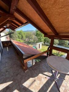 a porch with a hammock and a table at Tri Cveta in Popadić