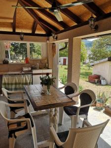 a table and chairs on a patio with a kitchen at Tri Cveta in Popadić