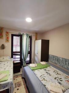 a bedroom with two beds and a window at Tri Cveta in Popadić