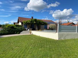 a house with a green lawn in front of it at L'Esprit Cottage in La Tranclière