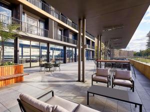 a building with a patio with chairs and tables at Wonil Hotel Perth - Handwritten Collection in Perth