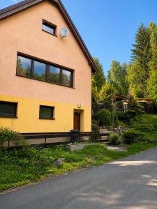 a yellow house with windows on the side of a road at Wellspace Forest Retreat in Karlovy Vary