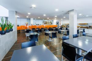 a dining room with tables and chairs in a restaurant at H2 Fuenlabrada in Fuenlabrada