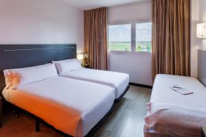 a hotel room with two beds and a window at H2 Fuenlabrada in Fuenlabrada