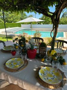 a table with plates of food on it next to a pool at L'Esprit Cottage in La Tranclière
