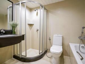 a bathroom with a shower and a toilet and a sink at Grand Mercure Bangkok Atrium in Bangkok