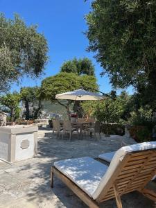 a patio with a table and an umbrella and chairs at Loukas house Paxos in Boïkátika
