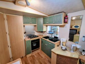 a green kitchen with wooden floors and green cabinets at Evasion Charente in Sémussac