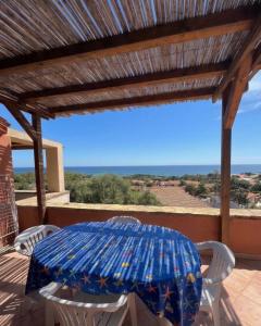 a table and chairs on a patio with an umbrella at Appartamenti Cala d'Ambra in San Teodoro +6 photos