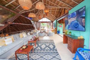 a living room with a couch and a tv at La Zebra Tulum, a Small Luxury Hotel in Tulum