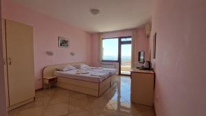 a bedroom with a bed and a large window at Guest House Byki in Sveti Vlas