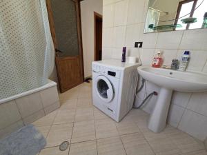a bathroom with a washing machine and a sink at Bujari Guesthouse in Berat