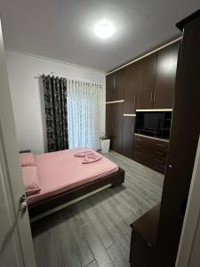 a bedroom with a pink bed and a television at Green Berat Villa in Uznovë