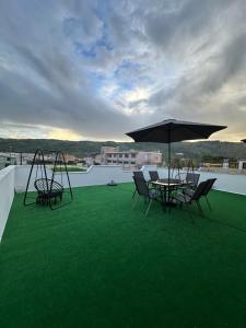 a patio with chairs and an umbrella on a roof at Green Berat Villa in Uznovë