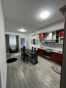 a kitchen and dining room with a table and chairs at Green Berat Villa in Uznovë