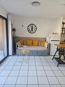 a living room with a couch and a clock on the wall at Moriani Plage San-Nicolao Les Marines de Moriani in San-Nicolao