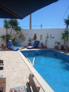 a swimming pool with chairs and plants on a building at Maison aux Jarres in Midoun