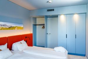 two beds in a room with blue walls at Stay2Munich Hotel & Serviced Apartments in Brunnthal +48 photos