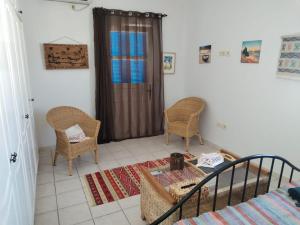 a room with a bed and two chairs and a table at Maison aux Jarres in Midoun