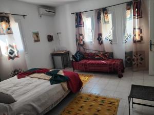 a bedroom with two beds and a couch in it at Maison aux Jarres in Midoun