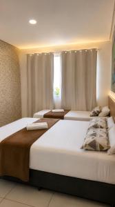 a bedroom with three beds in a room at Pousada Doce Mar in Maragogi