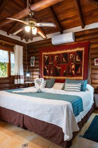 a large bed in a room with wooden walls at Cabañas Mapuche in Mar de las Pampas +170 photos