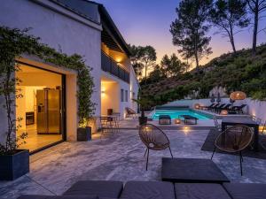 a patio with a table and chairs and a pool at Arty Provence, vue, calme et piscine chauffée dans les Alpilles proche St-Rémy-de-Provence in Saint-Étienne-du-Grès