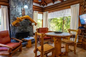 a living room with a table and chairs and a fireplace at Cabañas Mapuche in Mar de las Pampas