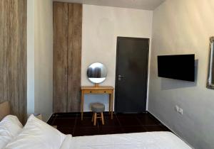 ein Schlafzimmer mit einem Bett und einem Schreibtisch mit Fernseher in der Unterkunft Valla Studio in Rhodos (Stadt)