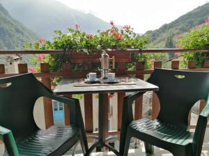 a table and chairs on a balcony with a view at Sotto il Cielo, Balcone panoramico sul borgo di Ingria in Ingria