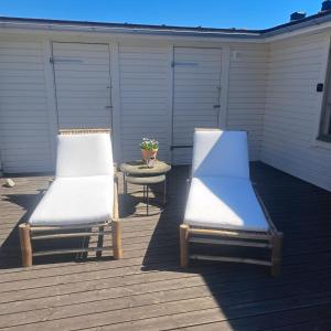 two lounge chairs and a table on a deck at Gästhus öppen planlösning in Oskarshamn