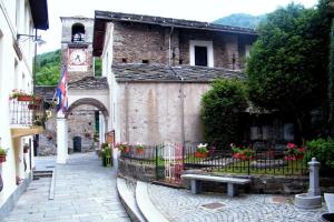 a building with a clock tower and a bench at Sotto il Cielo, Balcone panoramico sul borgo di Ingria in Ingria
