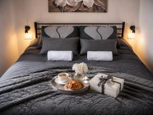 a bed with a tray of croissants and a gift at Center Vibes Lux in Rijeka +41 photos